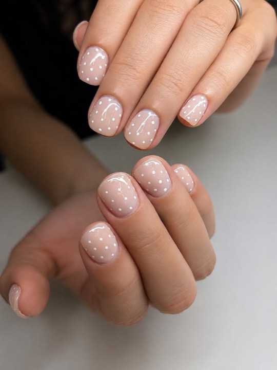 Soft nude builder-gel manicure with white polka dots
